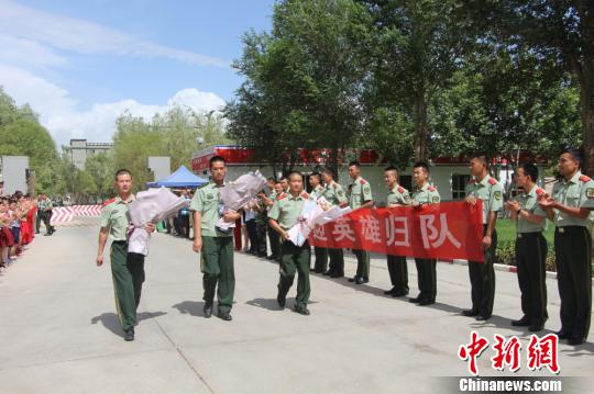部隊官兵們迎接出院歸來的李運飛(中)和其他消防戰(zhàn)士。　汪渝 攝