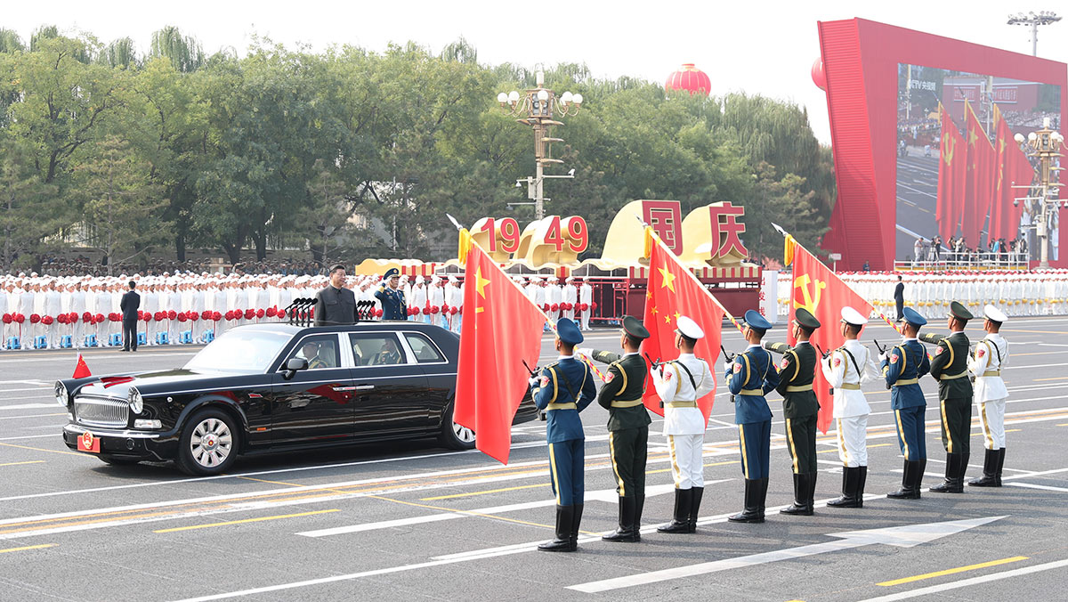習(xí)近平驅(qū)車行進(jìn)至黨旗、國旗、軍旗前，向旗幟行注目禮