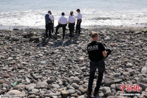 當?shù)貢r間8月2日，法屬留尼旺首府圣但尼附近的一處海灘上，警員正在現(xiàn)場對金屬殘片進行勘察。